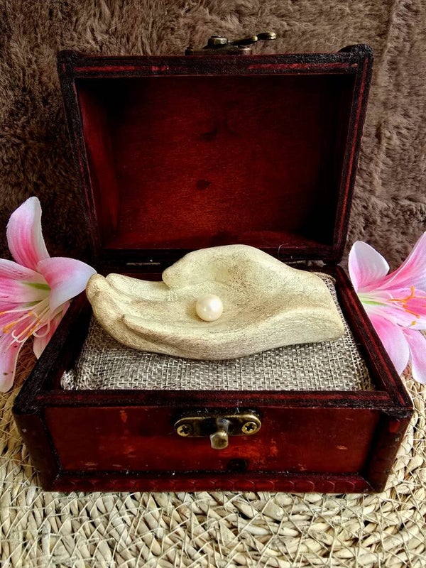 Decoratieve dragende hand met glanzende parel – Betekenisvol christelijk symbool