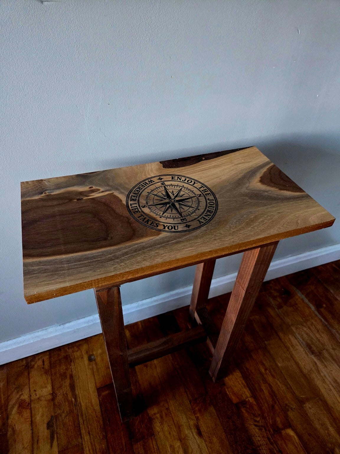 Wooden end table with a compass engraved into its richly patterned top