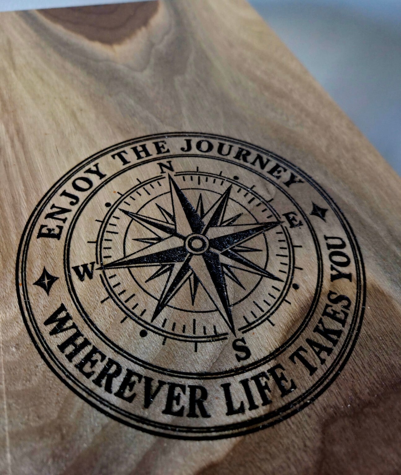 Close-up of the compass engraving and Enjoy the journey message