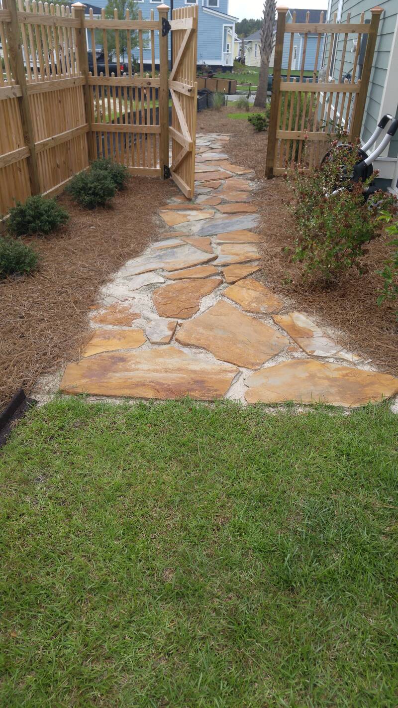 natural stone walkway with wooden fence