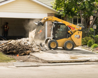 Maison détruite après démolition, un Bobcat ramasse les débris au sol – service de démolition et nettoyage de rebuts par DEMOVA à Montréal