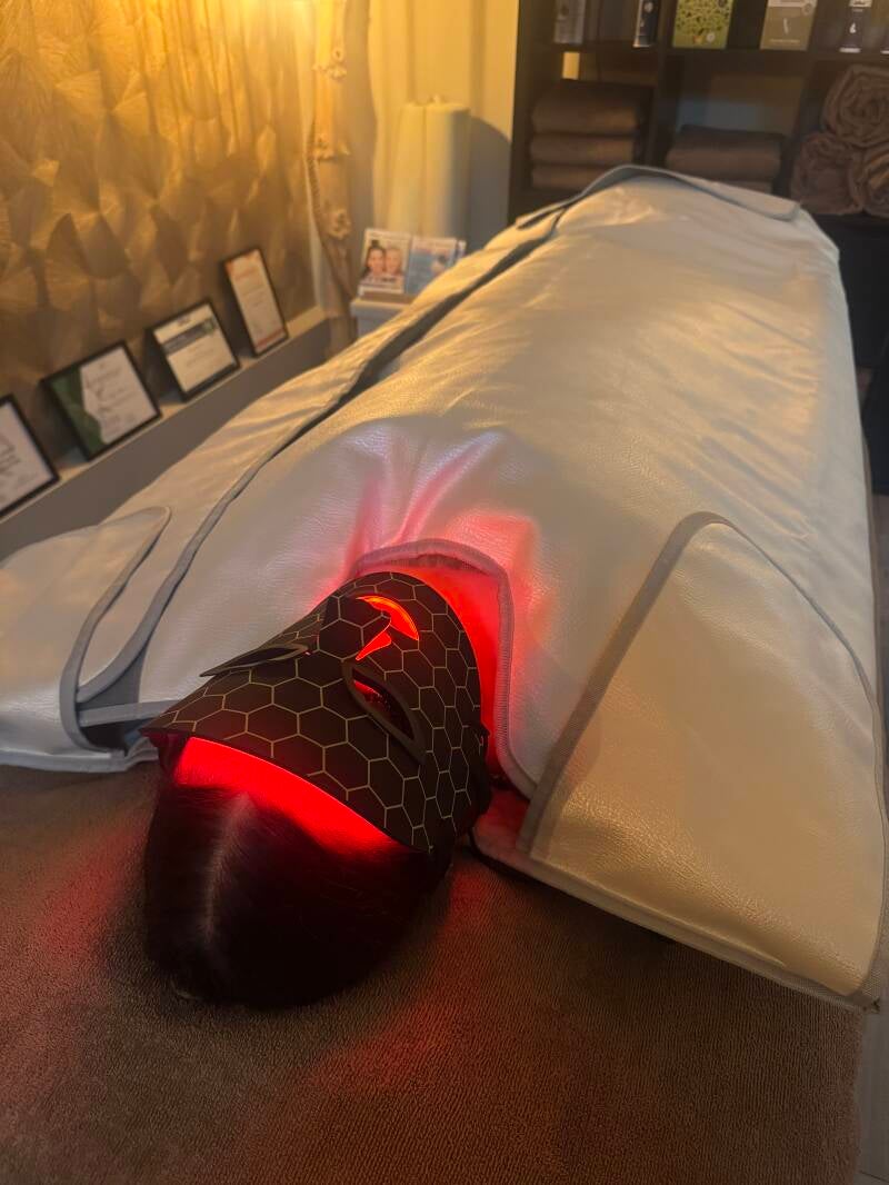 Klant ligt in een Magnesium Pakking en LED gezichtsmasker roodlicht therapie