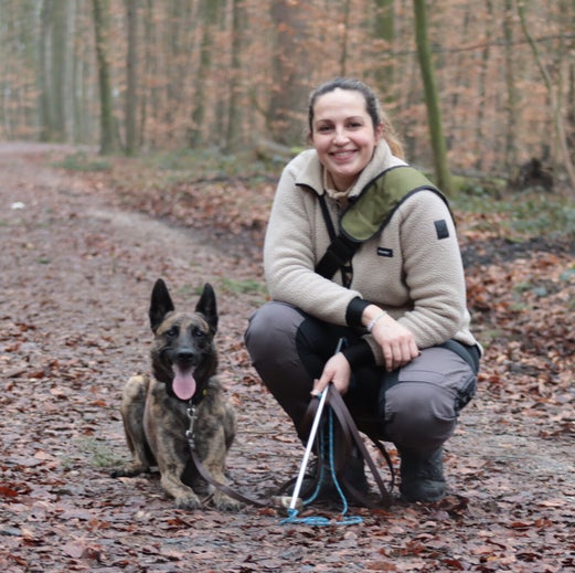 Christina mit ihrem Hund auf einem Waldweg
