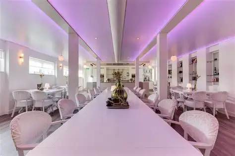 Sfeervolle dinerzaal van LEV. by Mike in Winterswijk met lange tafel en paarse verlichting