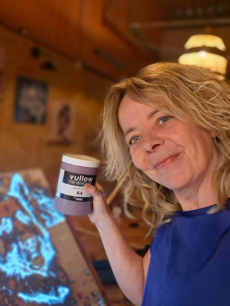 Mathilde van THILS Workshops & Creaties in haar schilderatelier in Lichtenvoorde, met een pot VULLOW-verf in haar hand voor de creatieve schilderworkshops.