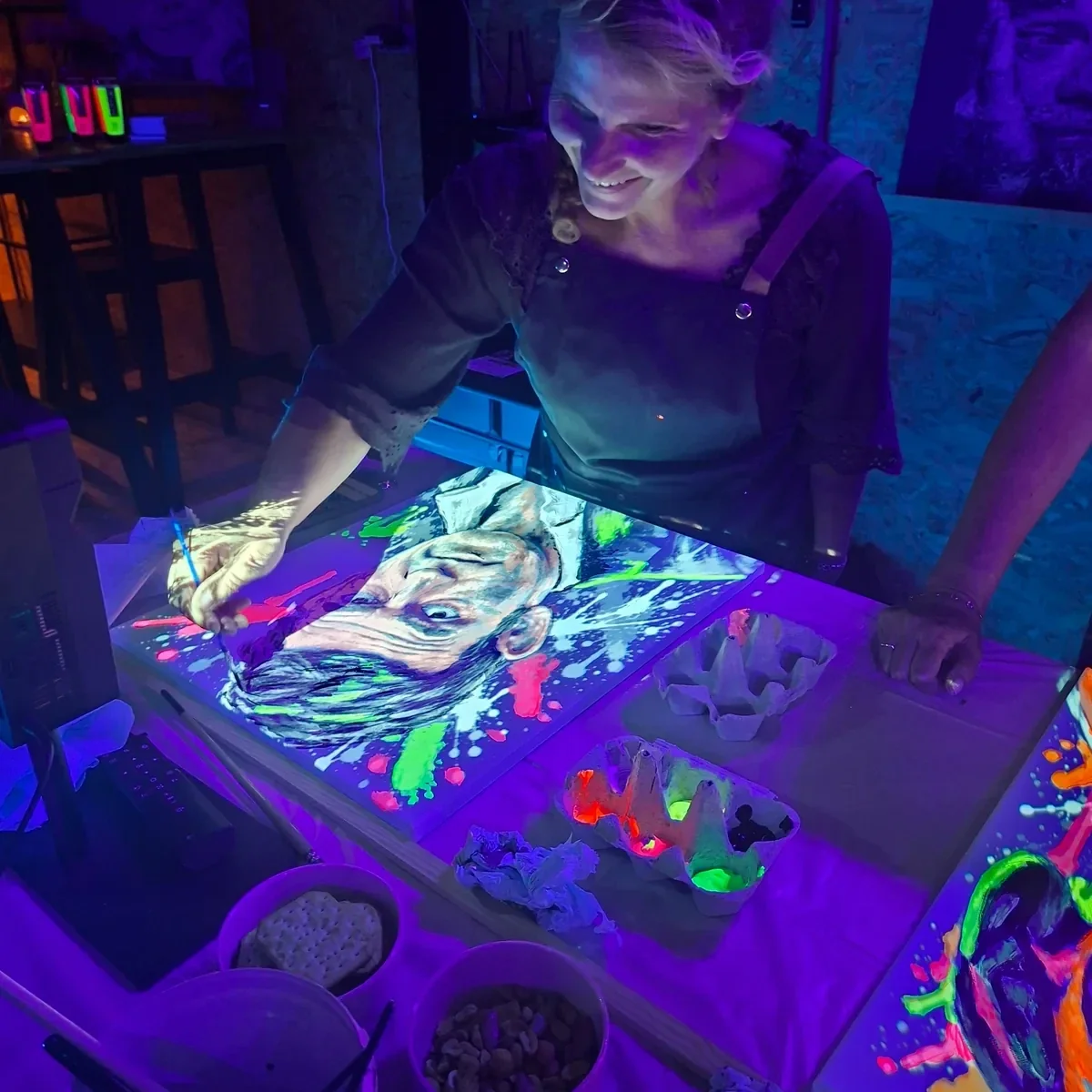 Deelnemers schilderen onder blacklight tijdens de Neon Pop-Art workshop bij THILS in Lichtenvoorde.