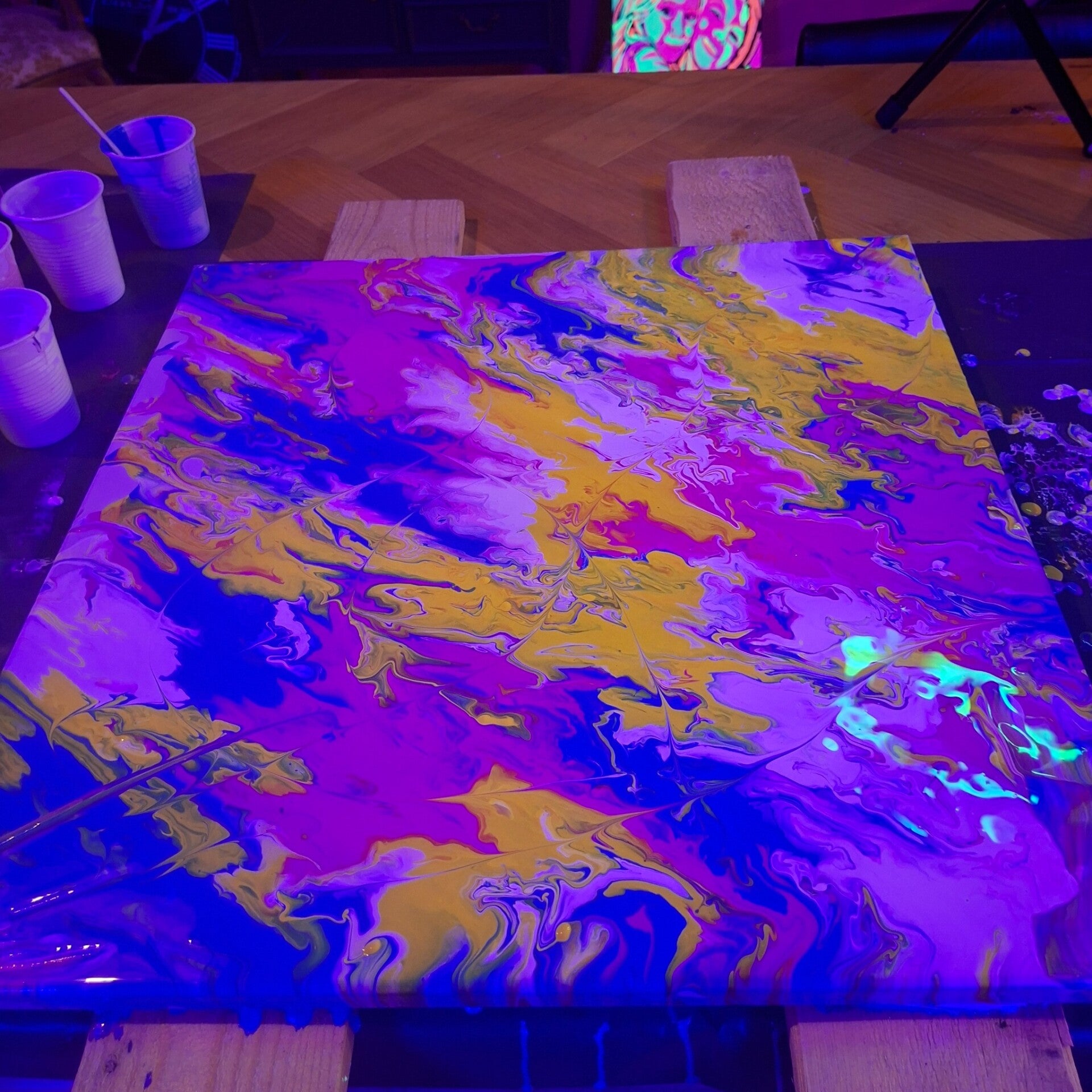 Neon pouring kunstwerk onder blacklight tijdens workshop bij THILS