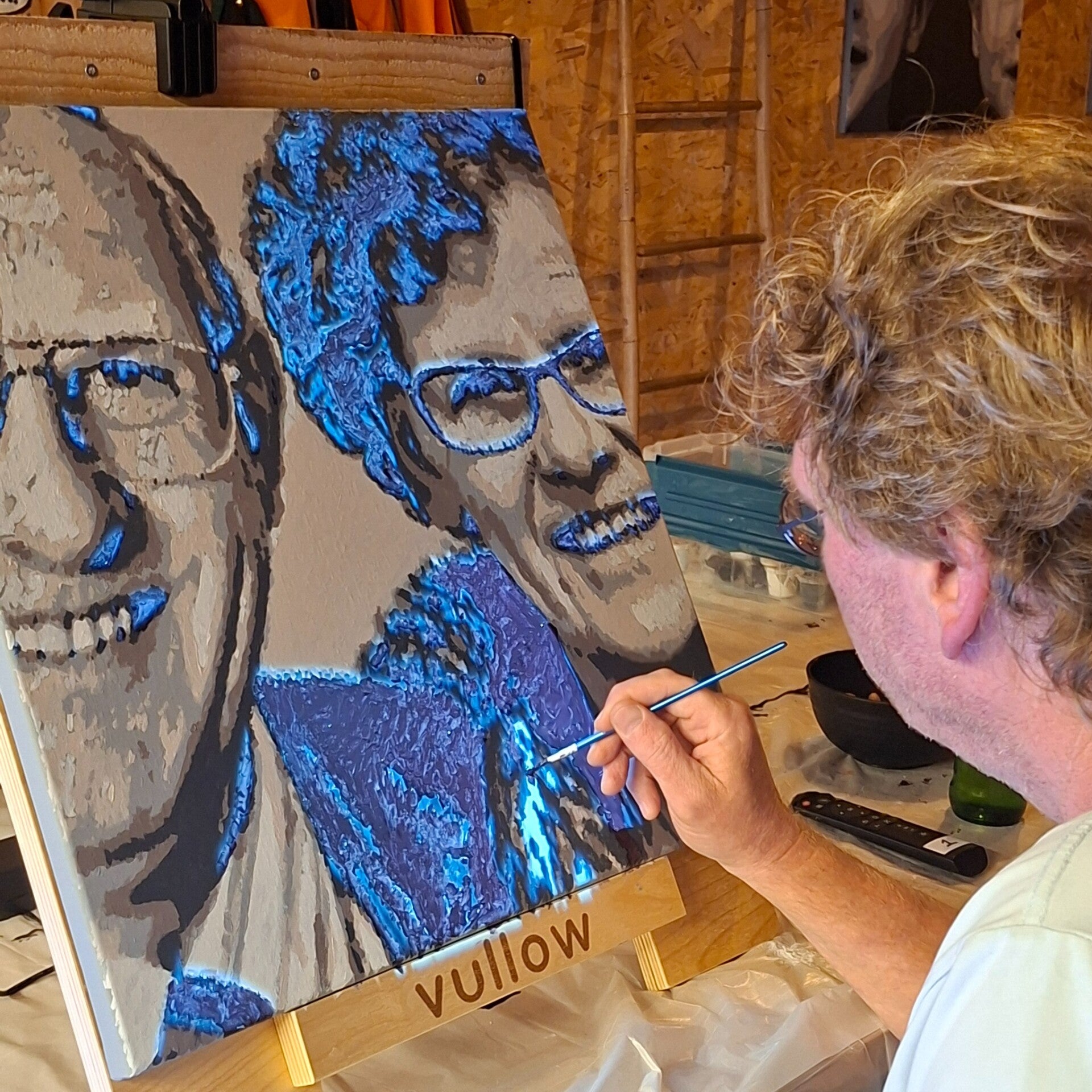 Man schildert twee lachende gezichten op één doek tijdens een VULLOW-portretworkshop bij THILS Workshops & Creaties.