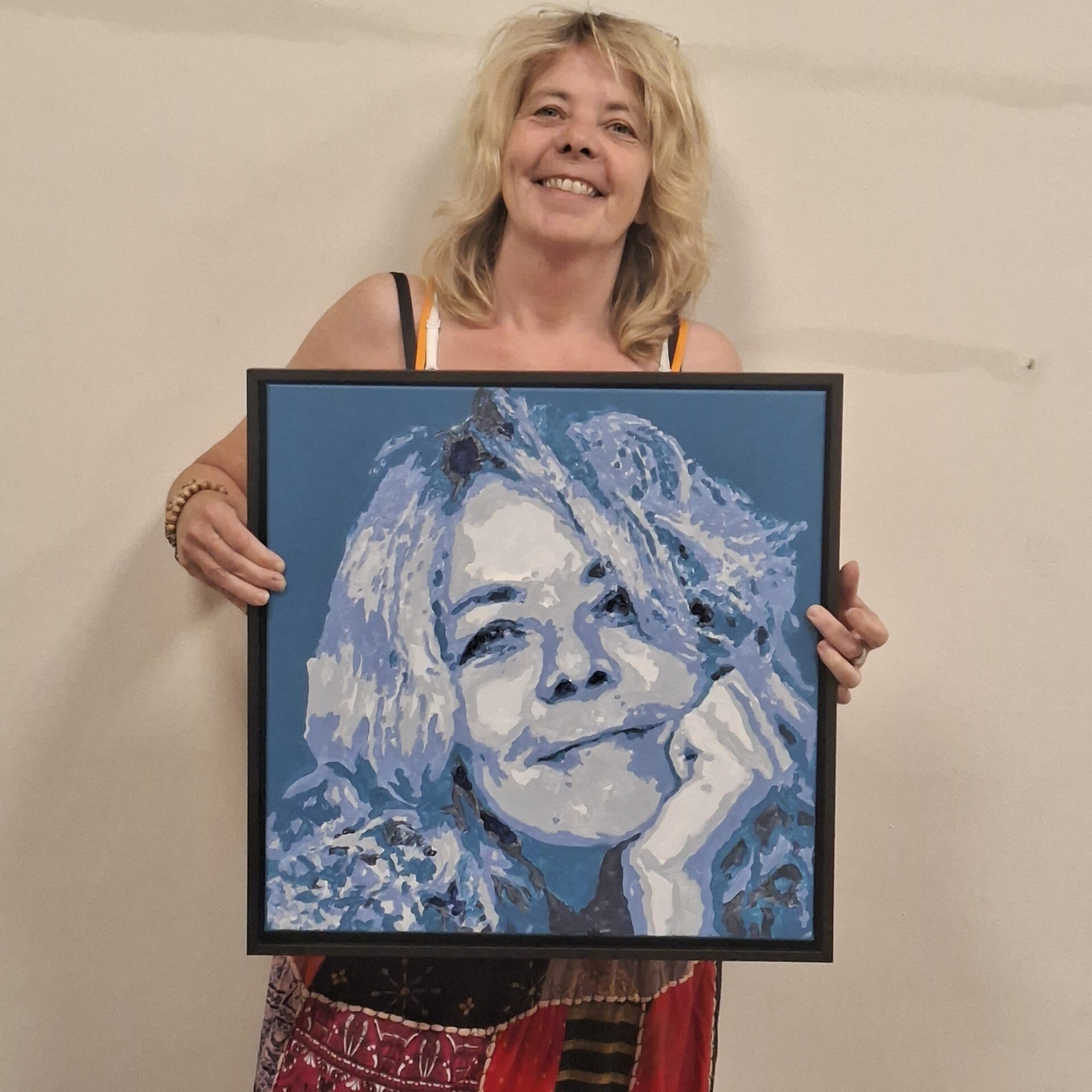 Deelnemer toont haar zelfgeschilderde portret tijdens een schilderworkshop bij THILS in Lichtenvoorde