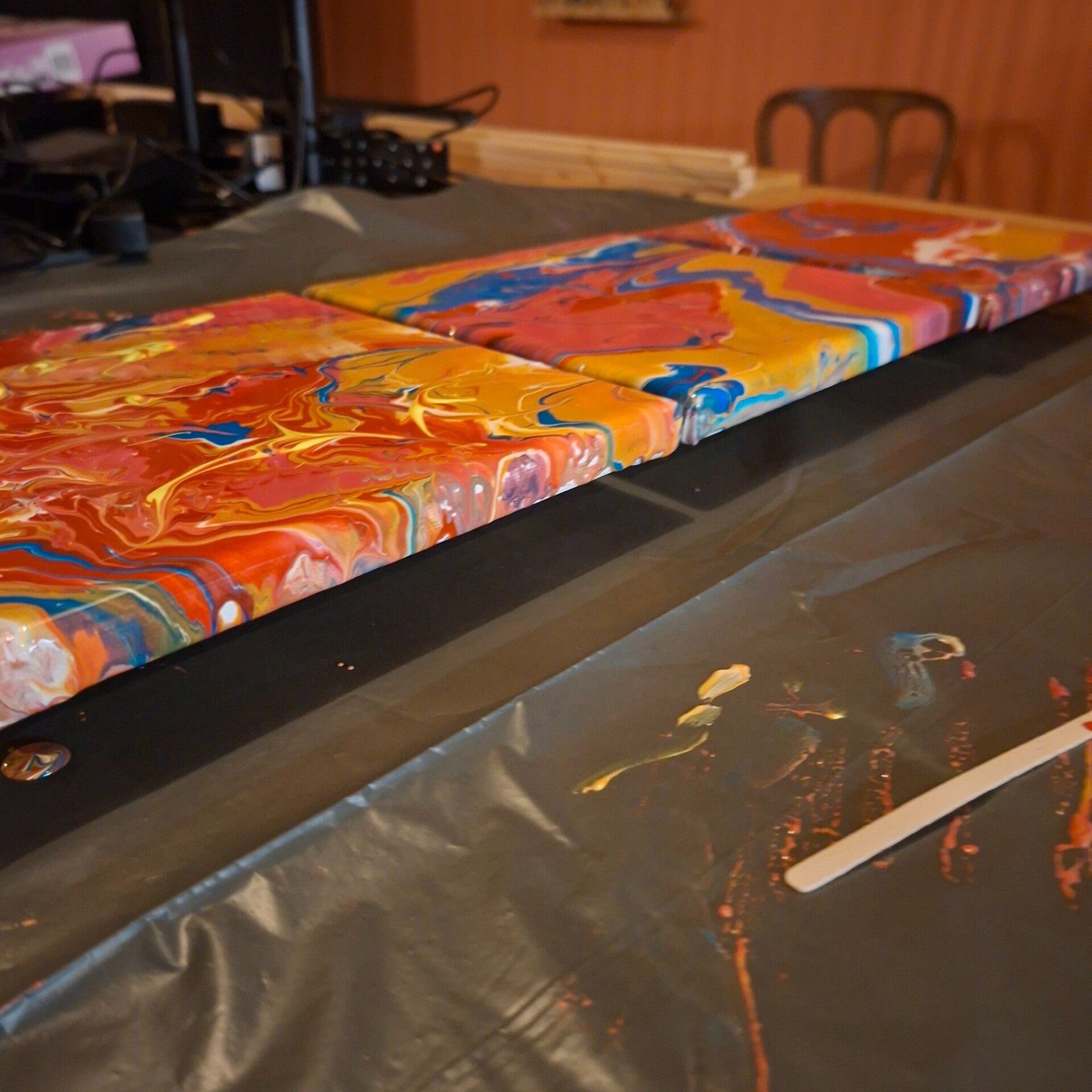 Meerdere pouring schilderijen op tafel tijdens creatieve workshop bij THILS