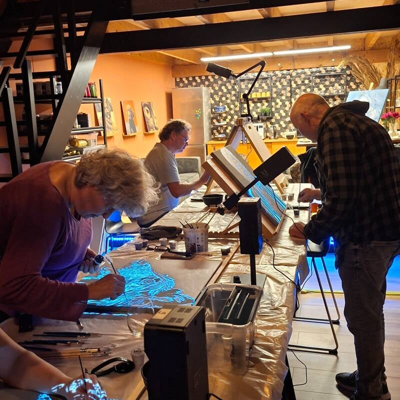 Deelnemers schilderen hun eigen portretten met projectoren tijdens een gezellige VULLOW-schilderworkshop in het atelier van THILS in Lichtenvoorde.
