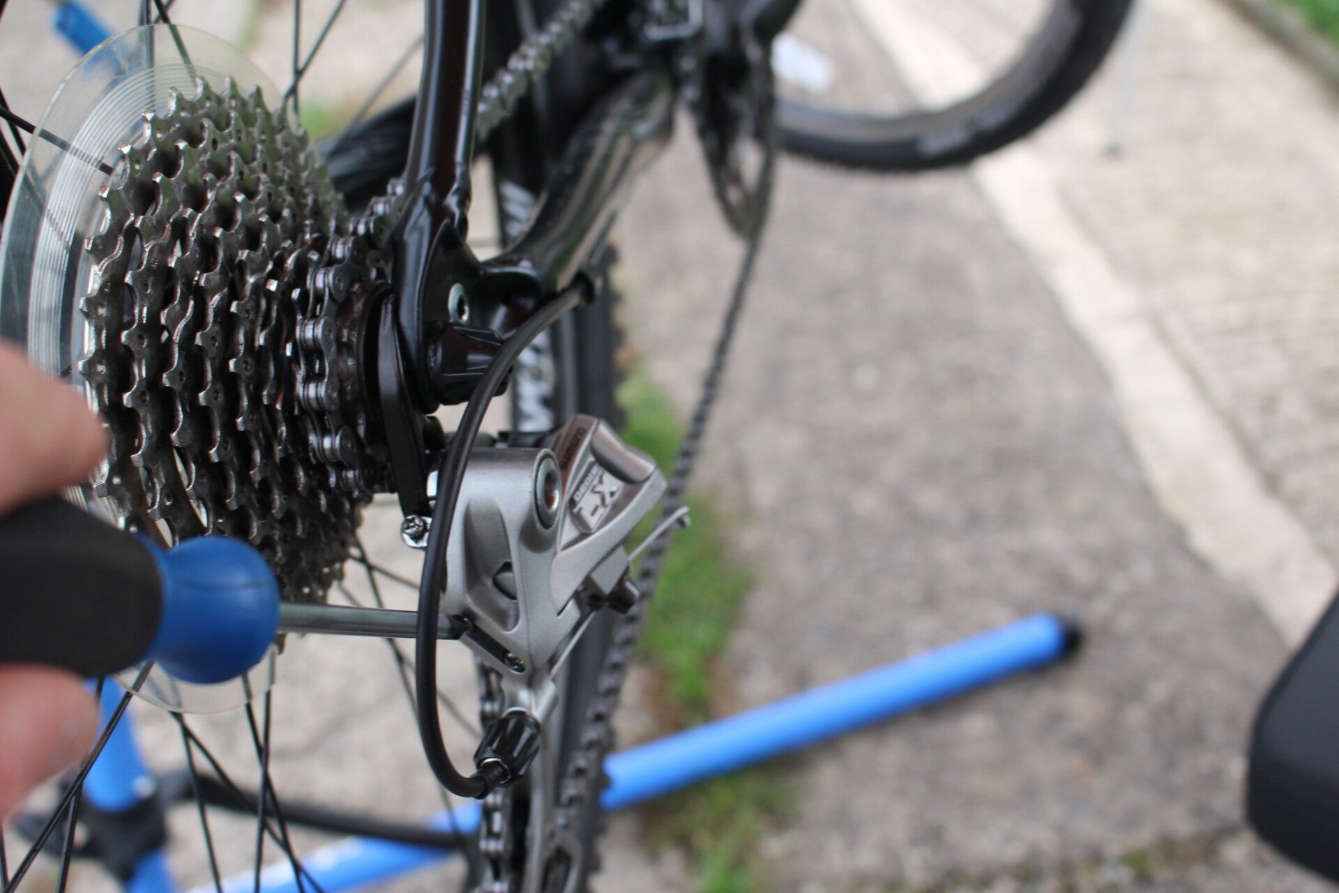 Close up of a mountain bike rear derailleur being adjusted showing precision and care