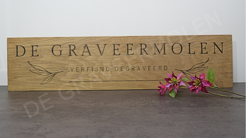 Gegraveerd eikenhouten gevelbord met tekst.