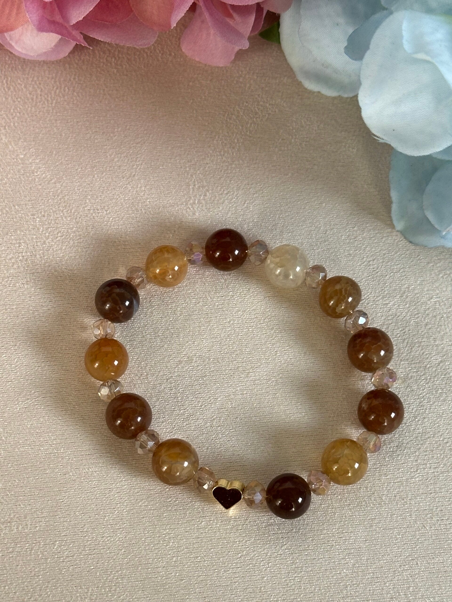 Pulsera elástica color crema y marrón con corazón en oro
