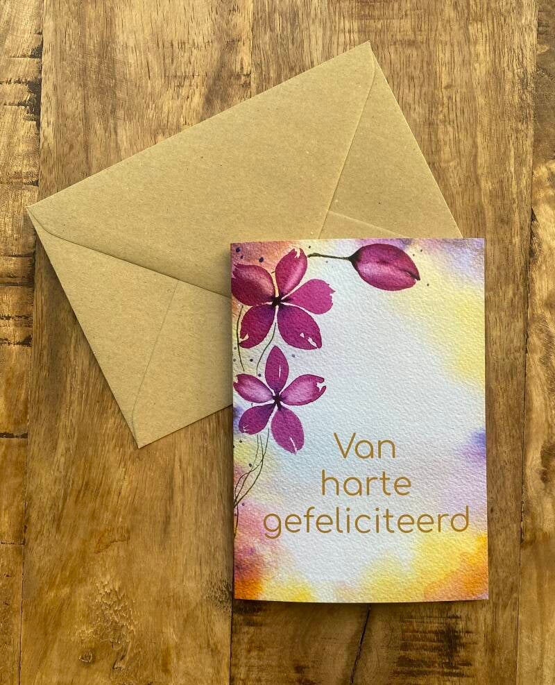 Een kleurrijke gevouwen wenskaart met  bloemen en van harte gefeliciteerd erop