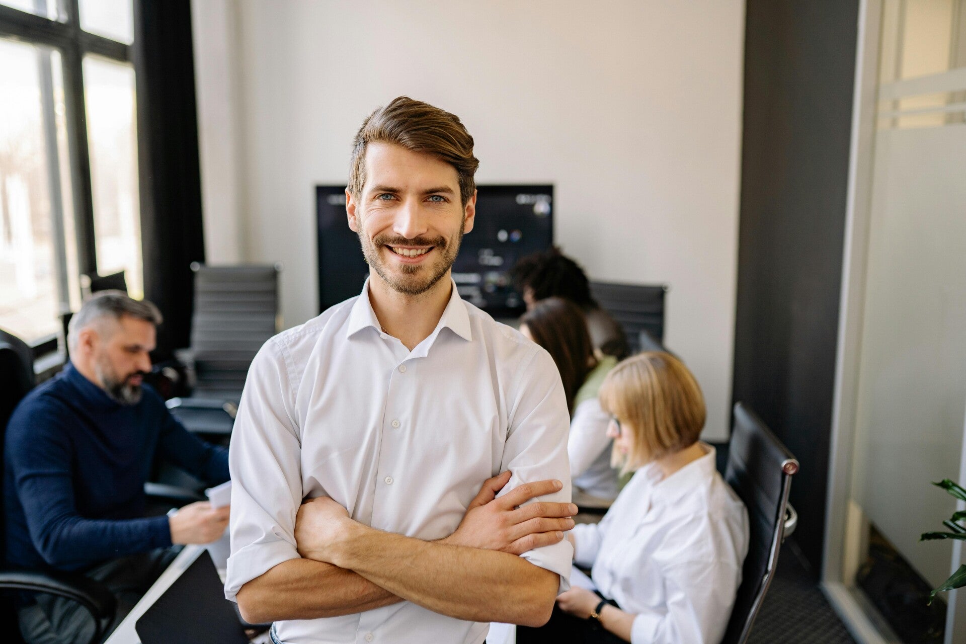 Business Mann laechelnd Arme verschraenkt