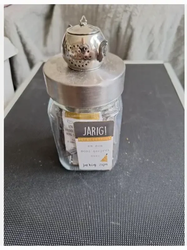 Glazen pot met thee en spel