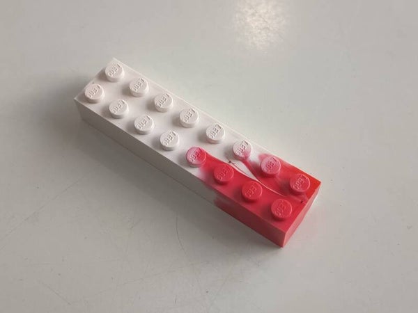 White 2x8 marbled brick with some red.