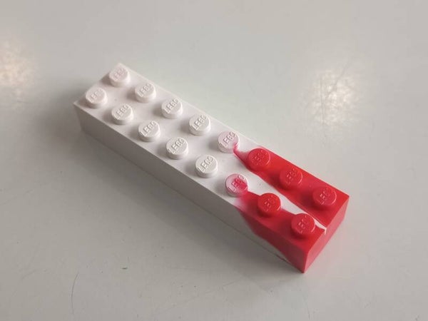 White 2x8 marbled brick with some red.