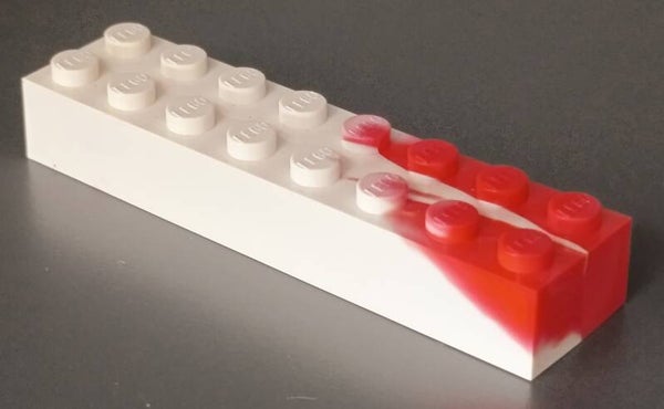 White 2x8 marbled brick with some red.