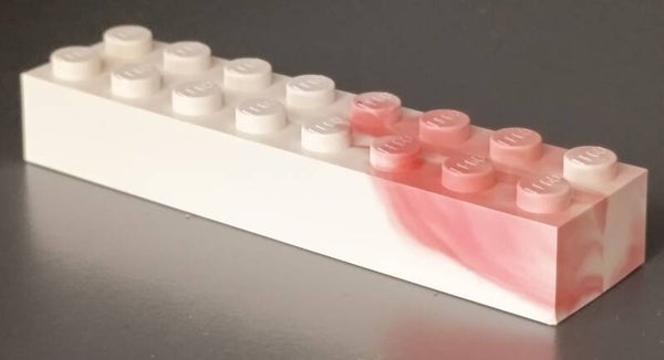 White 2x8 marbled brick with some red.