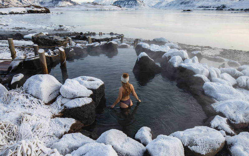 Woman entering natural hot springs in Iceland.