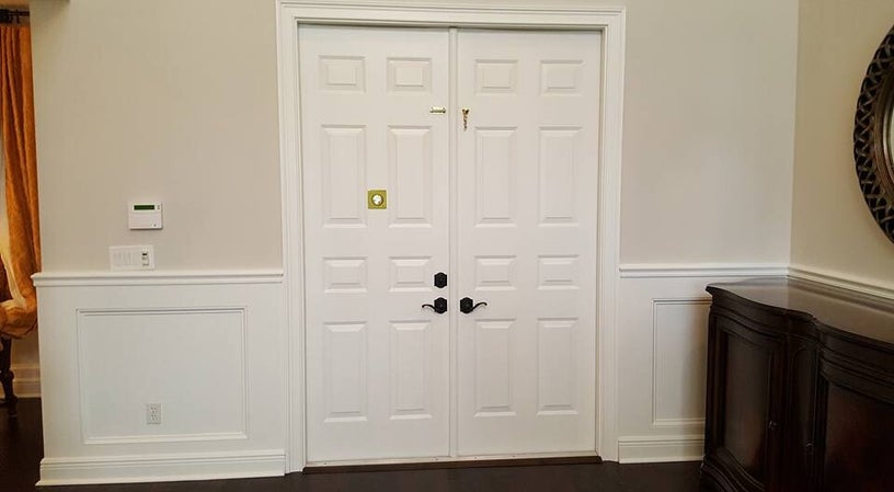 Box wainscoting flanking a set of white double doors