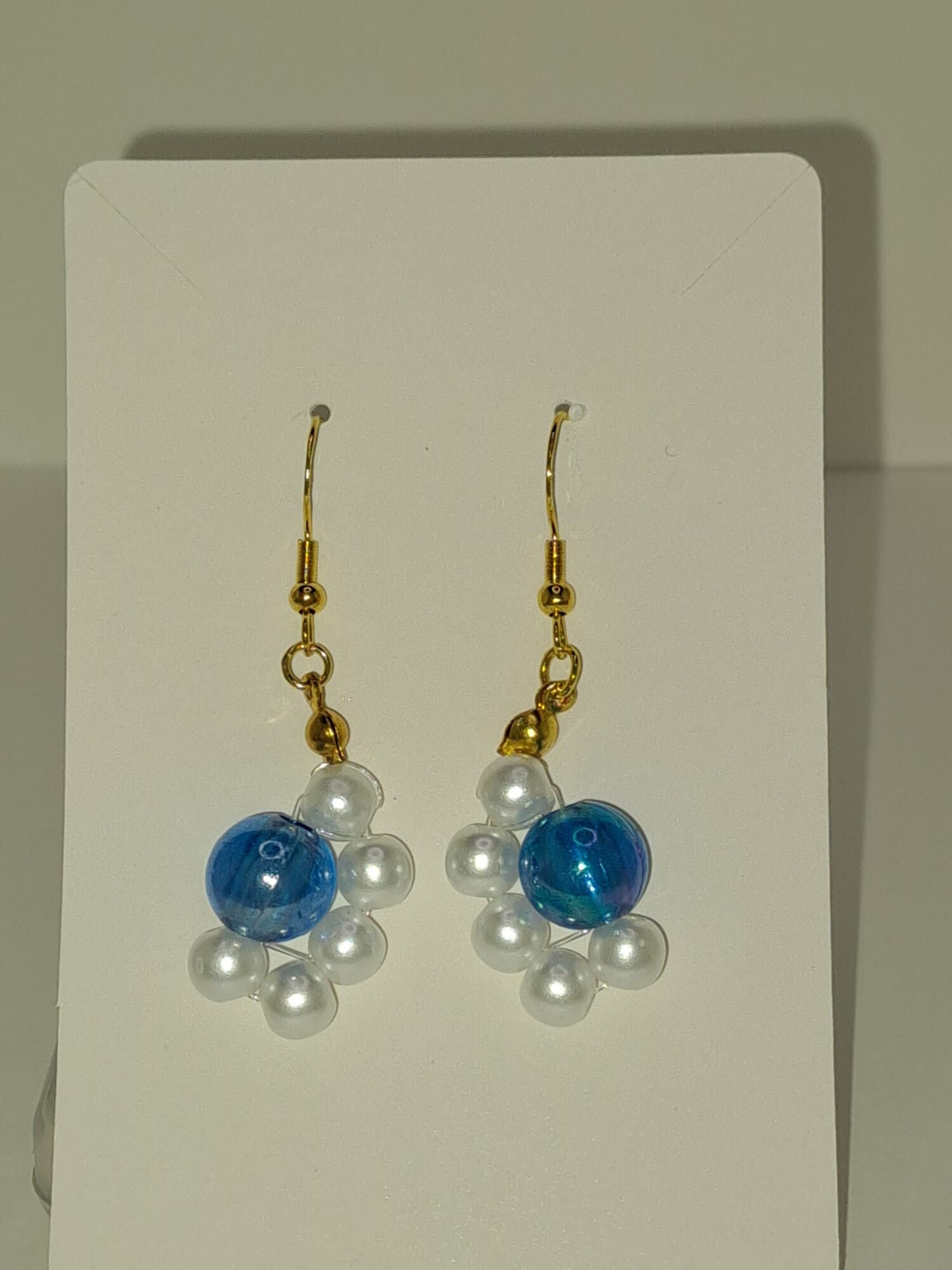 Frostzauber – Goldfarbenen Ohrhänger mit blauer Blüte & Kristallperlen