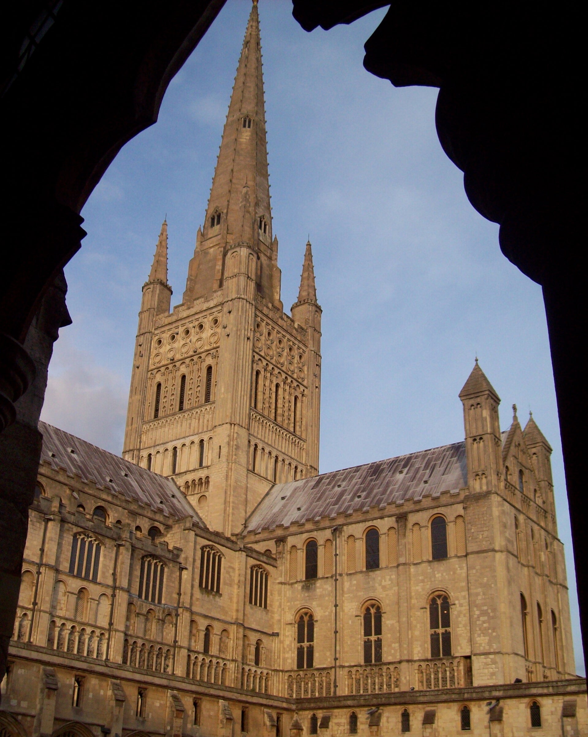 Atmospheric view of a historic English Cathedral at dusk, showcasing grand Gothic architecture.