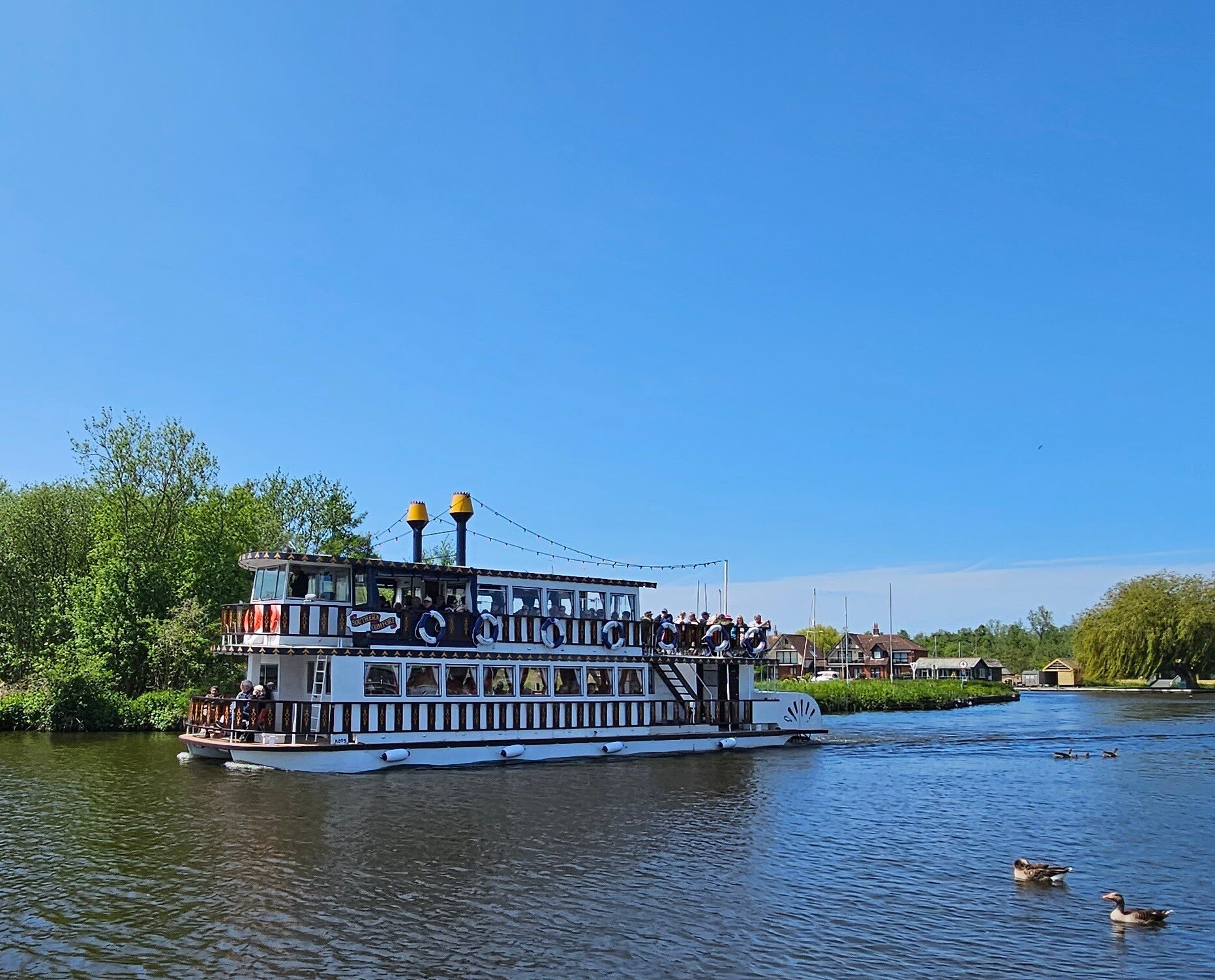 The Southern Comfort paddle steamer, a traditional double-decker stern-wheeler cruising the peaceful Norfolk Broads