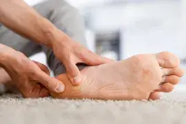 Persoon met hielspoor klachten die hielpijn masseert - Podotherapie Perform Deurne