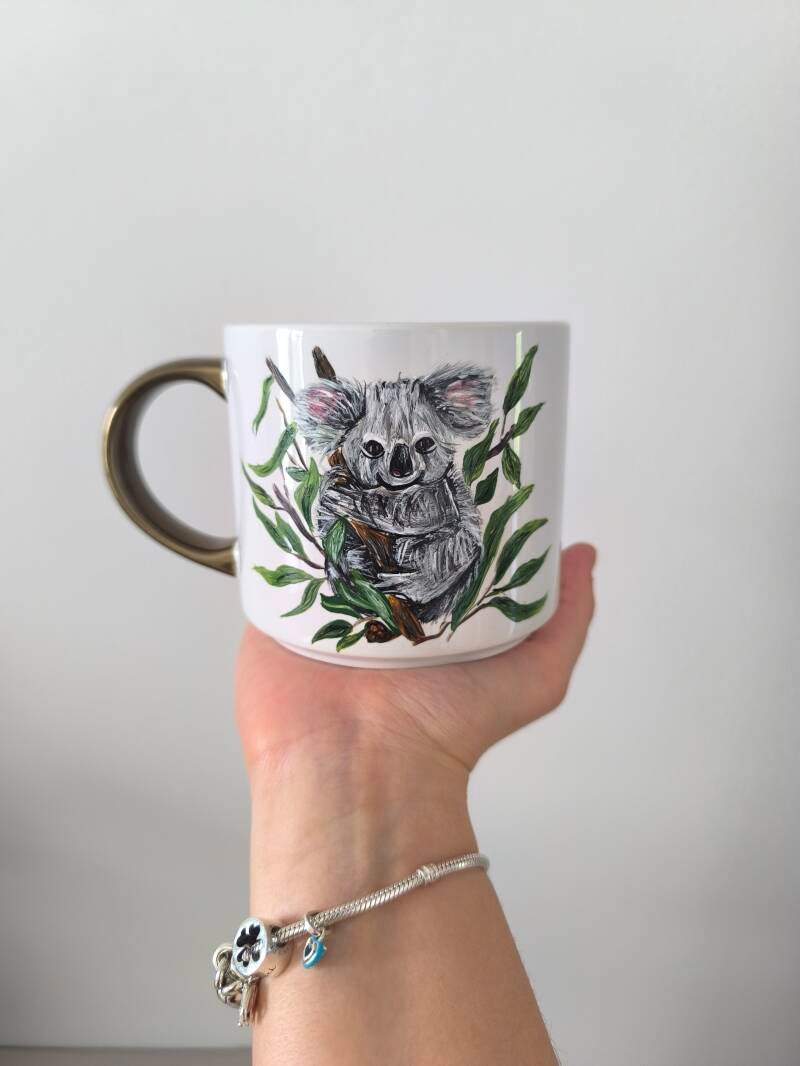 Kubek ręcznie zdobiony z kolorowym wizerunkiem króliczka, praktyczny i trwały.