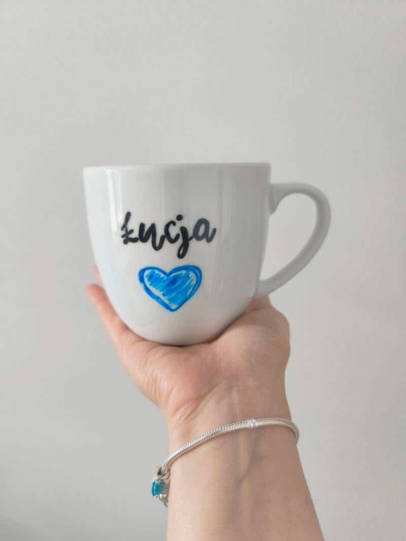 Kubek ręcznie zdobiony z motywem słoni i kolorowych balonów.