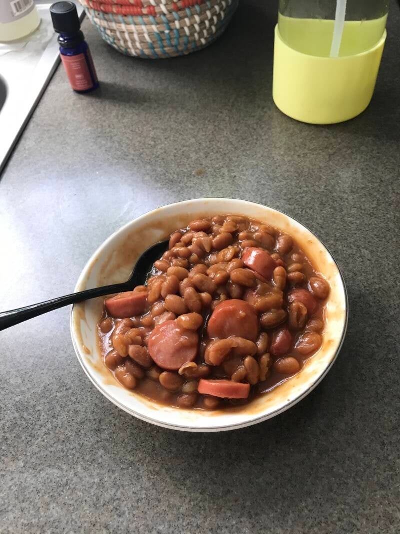 A warm bowl of Cannabis Hot Dogs and Baked Beans, a perfect meal for cannabis edibles and stoner strategies enthusiasts.