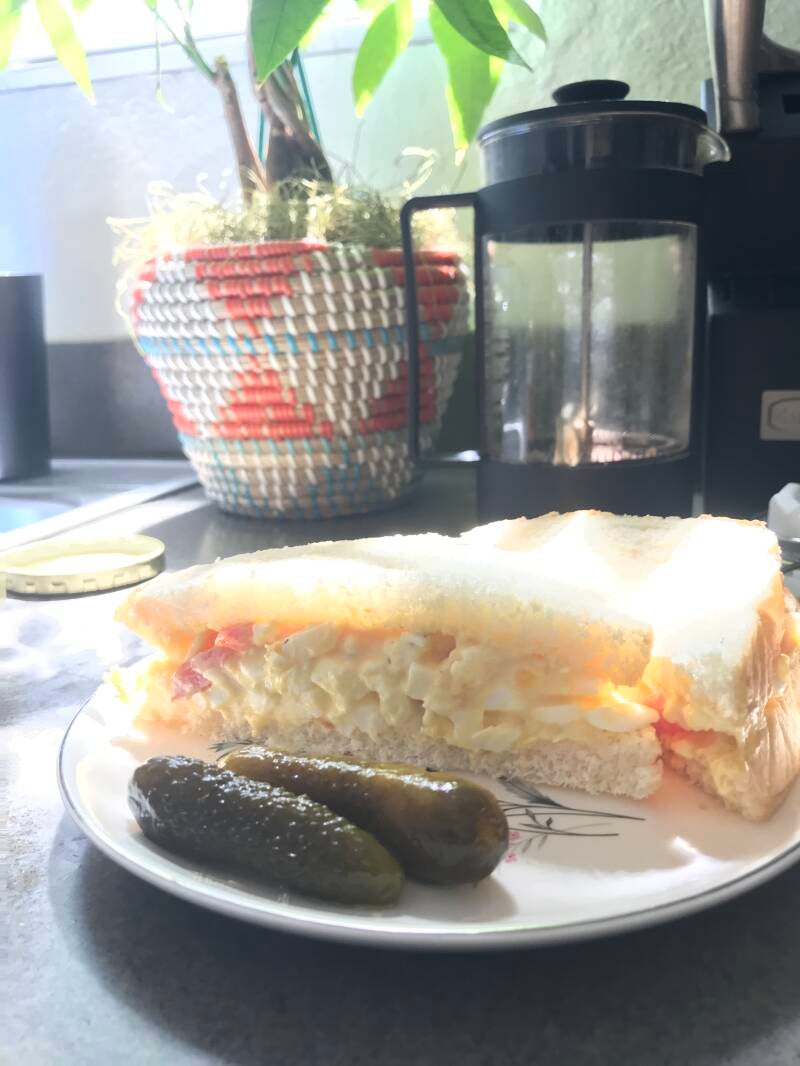 A plate with a delicious Cannabis Egg Salad Sandwich, perfect for cannabis edibles and stoner strategies enthusiasts.