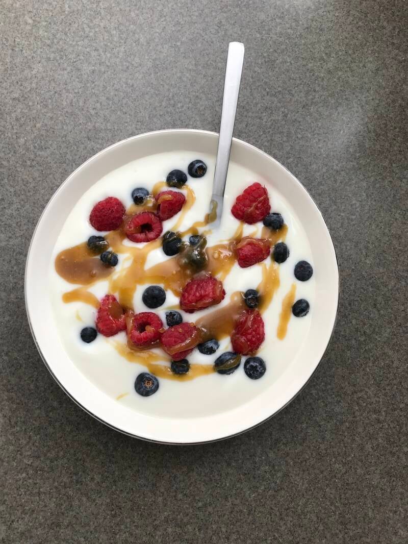 A fresh bowl of yogurt with berries and cannabis honey, the perfect breakfast for cannabis edibles and Stoner Strategies enthusiasts