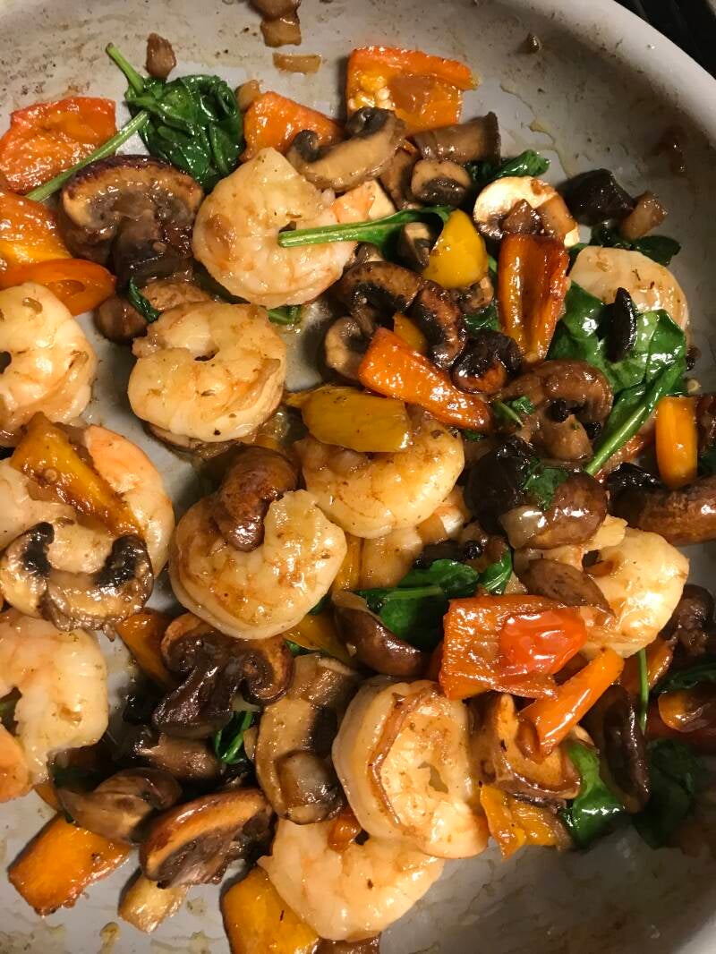 A plate of savory Black Garlic Shrimp with peppers and spinach, a gourmet meal for cannabis edibles and Stoner Strategies readers