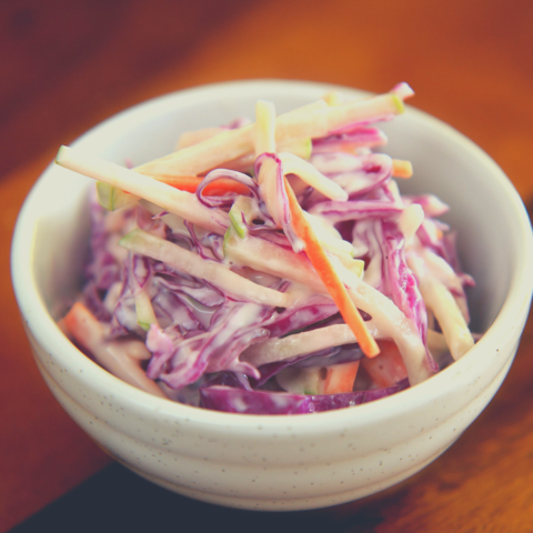 A bowl of fresh, colorful cabbage and carrot salad tossed in a creamy dressing, ready to serve
