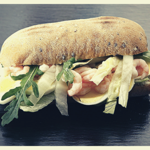 A gourmet shrimp sandwich on a fresh roll with sliced hard-boiled eggs, lettuce, cannabis edibles recipe
