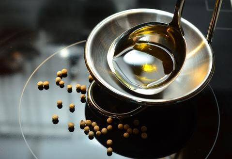 Close-up of golden concentrate-based butter in a spoon prepared for making professional-grade cannabis edibles