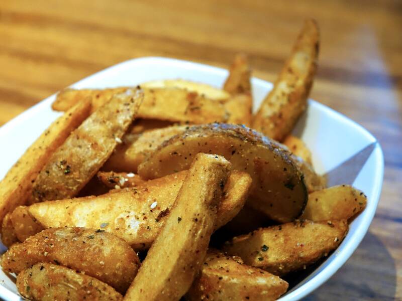 A platter of golden Baked Cannabis Potato Wedges, perfect for cannabis edibles and Stoner Strategies enthusiasts.