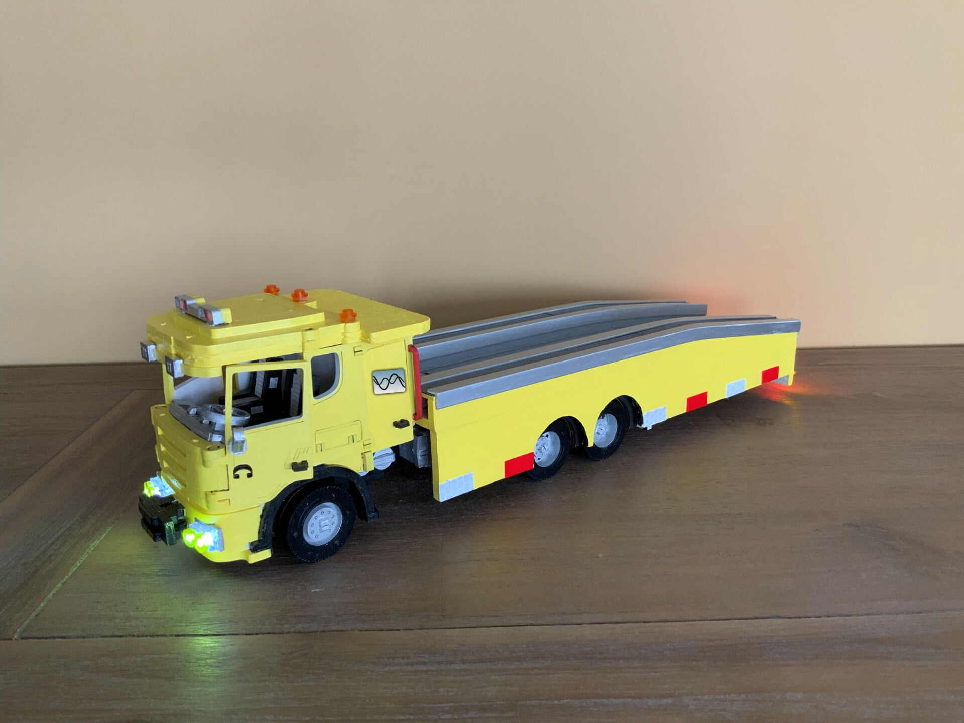 "Gedetailleerd model van een gele flatbed takelwagen met Jeep, handgemaakt door Aloijs."