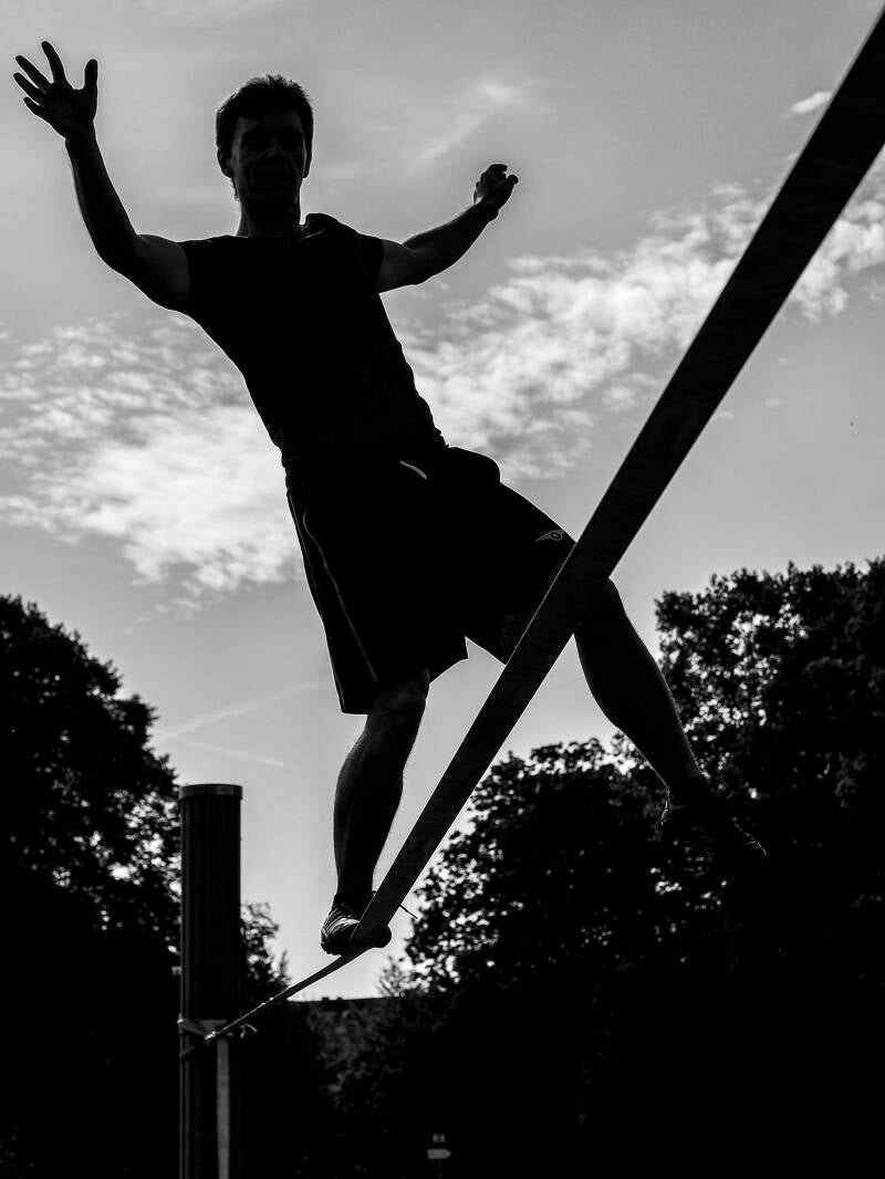 Evenwicht en stabiliteit. Bij slacklinen is het de kunst om het zwaartepunt boven het smalle steunvlak te houden. | natuurkundesite.nl