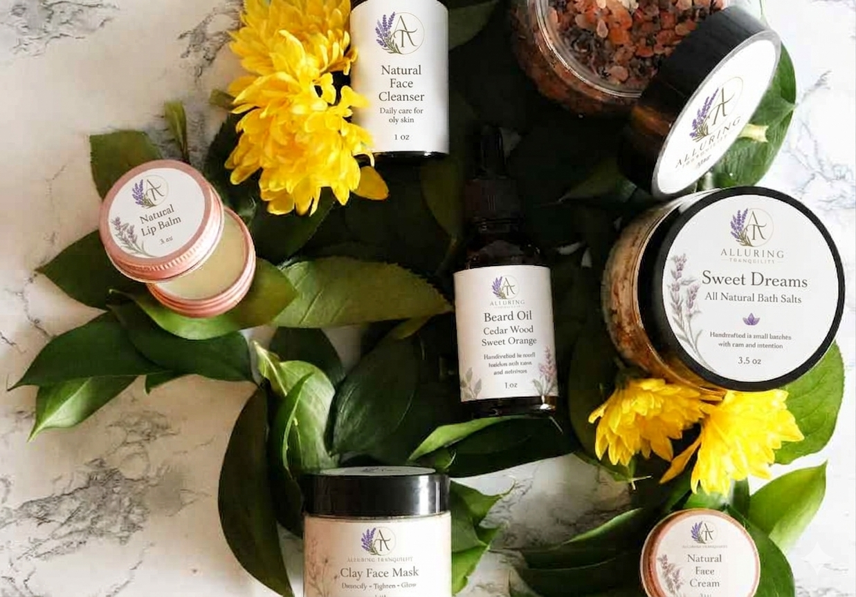 A bed of yellow flowers with green leaves, on it are closed and open jars, an open jar of lip balm on the left side, an open jar of bath salts in the upper right, a closed jar of bath salts, a bottle of natural face cleaner, a more