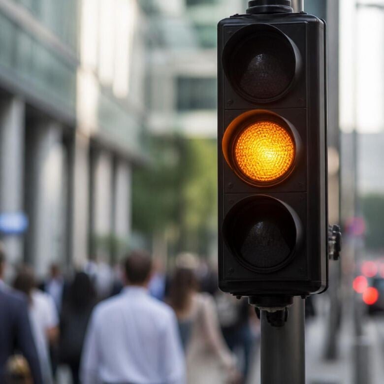 Verkeerslicht op oranje als metafoor voor het tijdig herkennen van signalen en het voeren van een preventief verzuimgesprek..