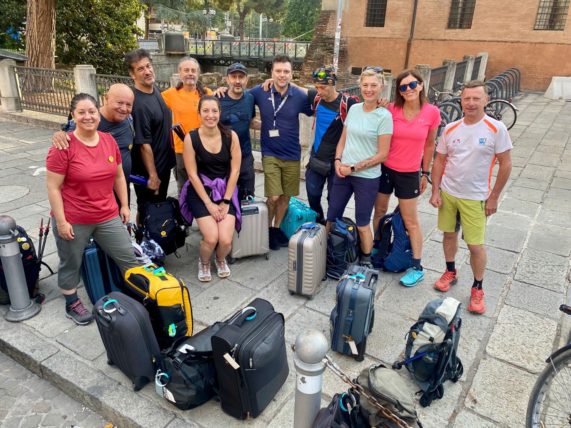 Gran Passo Service with a group of hikers led by a guide with all their luggages, backpacks and suitcases.