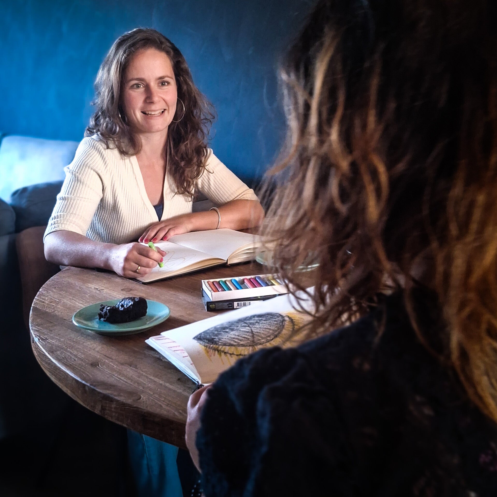 Twee vrouwen aan tafel tijdens coaching gesprek