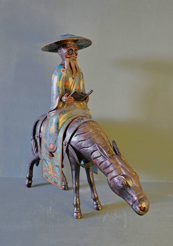 Een grote Chinese bronzen en cloisonné geëmailleerde figuur op een ezel.