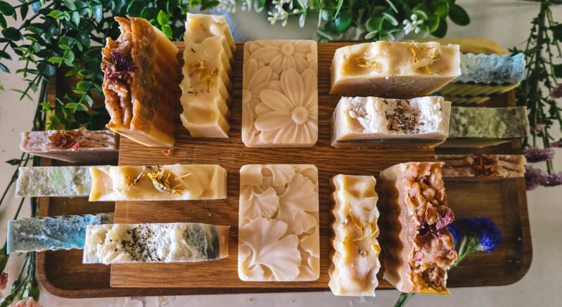 Handmade goat milk soap bars in assorted scents arranged on a wooden tray