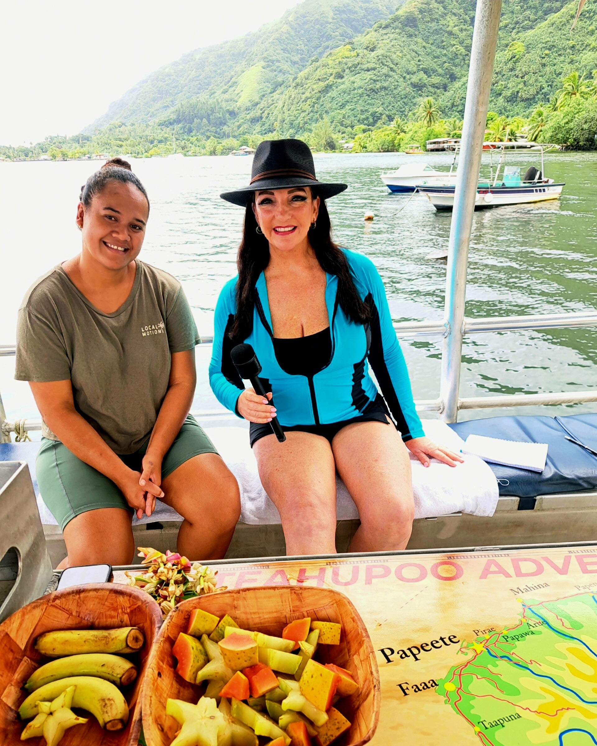 Travel journalist Terri Guthrie interviewing a local tour guide on a boat during a media trip in Tahiti.